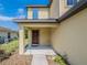 Inviting covered front porch with a stylish dark-stained front door that provides shelter and charm at 938 Mansfield Rd, Tavares, FL 32778