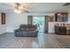 Open-concept living space featuring a comfortable sofa, sliding glass door, and a ceiling fan at 938 Mansfield Rd, Tavares, FL 32778