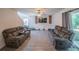 Spacious living room with a wall-mounted TV, cozy couches, sliding glass doors, and neutral wall colors at 938 Mansfield Rd, Tavares, FL 32778