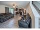 Open-concept living room featuring modern grey sofas, laminate floors, and seamless access to the kitchen at 938 Mansfield Rd, Tavares, FL 32778