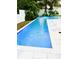 A pristine pool with cool blue water is surrounded by lush tropical foliage and a white-tiled deck at 1234 W Ivanhoe Blvd, Orlando, FL 32804