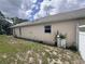 Side view of property with green yard and exterior wall showcasing window and white fence at 2921 Blackburn Ave, Deltona, FL 32738