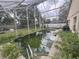 Screened-in pool needing maintenance and surrounded by an overgrown brick deck and greenery at 2921 Blackburn Ave, Deltona, FL 32738