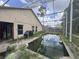 Backyard and pool with screened-in enclosure, overgrown foliage, and the home's exterior at 2921 Blackburn Ave, Deltona, FL 32738