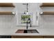 Bright kitchen featuring quartz countertops, a stainless steel sink, and a view to the outdoors at 584 Brantley Terrace Way # 200, Altamonte Springs, FL 32714