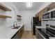 Modern kitchen with stainless steel appliances, ample counter space, and stylish floating shelves at 584 Brantley Terrace Way # 200, Altamonte Springs, FL 32714