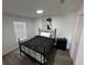 Cozy bedroom features a black and white patterned comforter, matching end table, and natural light through a window at 1980 Water Ln, Maitland, FL 32751