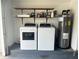 Functional laundry area in garage with modern washer and dryer, and a water heater at 1980 Water Ln, Maitland, FL 32751