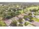 Aerial view of homes near a golf course with mature trees, providing a serene and private setting at 2000 Farmington Ct, Clermont, FL 34711