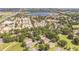 Aerial view showcasing a residential community with a lake, clubhouse, and well-manicured lawns at 2000 Farmington Ct, Clermont, FL 34711