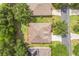 Aerial view of a home's roof, yard, and driveway in a neighborhood with mature trees at 2000 Farmington Ct, Clermont, FL 34711