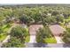 An aerial view shows a well-maintained home surrounded by mature trees and lush landscaping at 2000 Farmington Ct, Clermont, FL 34711