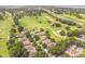 Aerial view showcases homes lining a golf course and a busy highway, blending recreation and convenience at 2000 Farmington Ct, Clermont, FL 34711