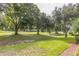 Picturesque backyard view of lush greenery and towering trees, creating a serene and inviting outdoor space at 2000 Farmington Ct, Clermont, FL 34711