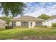 A cozy single-story home featuring a well-kept lawn, complemented by neatly trimmed shrubs and classic shuttered windows at 2000 Farmington Ct, Clermont, FL 34711