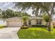 Charming single-story home with well-manicured lawn and inviting front yard landscaping with a two-car garage at 2000 Farmington Ct, Clermont, FL 34711