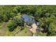 Aerial view of a secluded home nestled amongst lush greenery with a long driveway and metal roof at 13450 E Lake Mary Jane Rd, Orlando, FL 32832