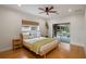 Cozy bedroom with wooden bed frame, hardwood floors and sliding glass door leading to pool at 13450 E Lake Mary Jane Rd, Orlando, FL 32832