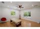 Bright bedroom with hardwood floors, two windows, a modern fan, and a massage table at 13450 E Lake Mary Jane Rd, Orlando, FL 32832