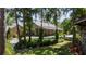 Charming home with wood siding, metal roof, lush landscaping, and mature trees providing shade and privacy at 13450 E Lake Mary Jane Rd, Orlando, FL 32832
