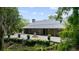 Beautiful home exterior featuring a stone patio, fountain, manicured greenery, and a durable metal roof at 13450 E Lake Mary Jane Rd, Orlando, FL 32832