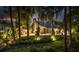 A beautiful exterior with manicured grounds, and a metal roof, framed by majestic trees during dusk at 13450 E Lake Mary Jane Rd, Orlando, FL 32832