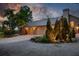 Elegant home exterior featuring a well-lit driveway, three-car garage, and lush landscaping at 13450 E Lake Mary Jane Rd, Orlando, FL 32832