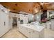 Open concept kitchen with marble island flowing into the living area and wood-clad vaulted ceiling at 13450 E Lake Mary Jane Rd, Orlando, FL 32832