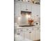 Close-up of a kitchen with white cabinets, marble backsplash and stainless steel range hood at 13450 E Lake Mary Jane Rd, Orlando, FL 32832