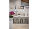 Close-up of the marble kitchen island with barstool seating and white cabinets with decorative display shelves at 13450 E Lake Mary Jane Rd, Orlando, FL 32832