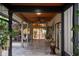 Covered outdoor patio featuring tile flooring, wood ceiling, seating, and access to outside at 13450 E Lake Mary Jane Rd, Orlando, FL 32832
