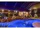 Inviting pool area with lush plants, rock accents, and a covered ceiling with elegant lighting for evening swims at 13450 E Lake Mary Jane Rd, Orlando, FL 32832