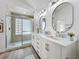 Well-lit bathroom featuring a double vanity, modern mirrors, a glass-enclosed shower, and stylish fixtures at 1437 Abberton Dr, Orlando, FL 32837