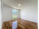 A bedroom featuring wood-look floors, a window, and white trim at 1437 Abberton Dr, Orlando, FL 32837