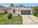 Well-maintained home featuring a blue garage door, neat landscaping, and a freshly manicured lawn enhancing its curb appeal at 1437 Abberton Dr, Orlando, FL 32837