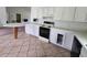 Functional kitchen with white cabinets, range, and breakfast bar with ceramic tile flooring at 860 S Grove St, Eustis, FL 32726