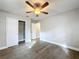 Bright bedroom with ceiling fan, wood-look floors, and spacious closet at 4201 Shadow Wood Dr, Winter Haven, FL 33880