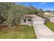 Front view of a single-story house with a large yard and a driveway at 4201 Shadow Wood Dr, Winter Haven, FL 33880