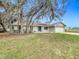 Single-story home with a spacious yard and a large tree in the front at 4201 Shadow Wood Dr, Winter Haven, FL 33880