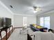 Living room with hardwood floors, ceiling fan, and large windows at 503 Se 3Rd St, Mulberry, FL 33860