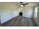 Bright bedroom featuring stylish wood flooring, a modern ceiling fan, and access to an ensuite bathroom at 9619 Moore Rd, Lakeland, FL 33809