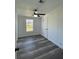 Bedroom with ceiling fan, window, and wood-look flooring at 9619 Moore Rd, Lakeland, FL 33809