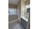 Bright bathroom with a tiled floor and a tub with shower surround under a window at 1024 Driggers Rd, Lakeland, FL 33809