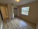 Bedroom featuring light walls, wood-look floors, a window, and a closet with white folding doors at 1024 Driggers Rd, Lakeland, FL 33809