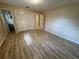 Bedroom with light walls, wood-look floors, closet with folding doors, and a door leading to the bathroom at 1024 Driggers Rd, Lakeland, FL 33809