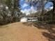 View of the front of the house with a lawn, garage, and mature trees at 1024 Driggers Rd, Lakeland, FL 33809