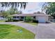 Charming single-story home with a well-manicured lawn, a blue door and an attached garage at 1025 E Georgia St, Bartow, FL 33830