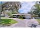 Charming single-story home with a well-manicured lawn, a large tree and a circular driveway at 1025 E Georgia St, Bartow, FL 33830