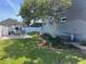 Landscaped backyard with grassy area, a table with chairs, and a mature shade tree at 121 Belmont Dr, Winter Haven, FL 33884