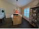 Open dining room features wood-look flooring, modern light fixture and shuttered window at 121 Belmont Dr, Winter Haven, FL 33884